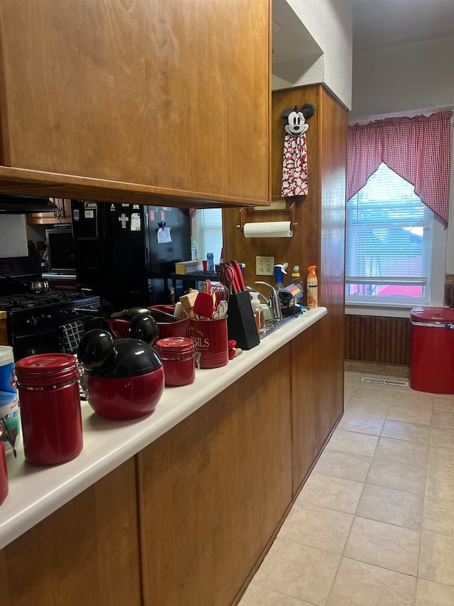 kitchen featuring light tile patterned flooring and black fridge