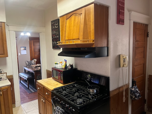 kitchen with black appliances, light hardwood / wood-style floors, and extractor fan