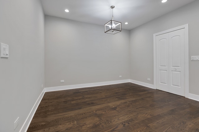 unfurnished dining area with a chandelier and dark hardwood / wood-style floors