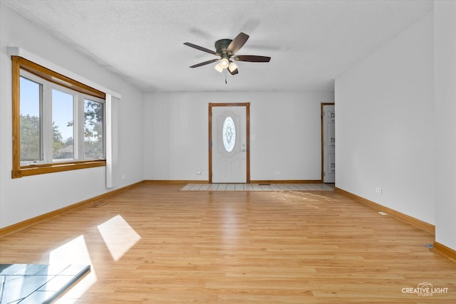 interior space featuring a textured ceiling, light hardwood / wood-style floors, and ceiling fan