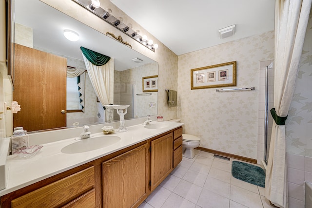 bathroom with vanity, toilet, tile patterned floors, and walk in shower