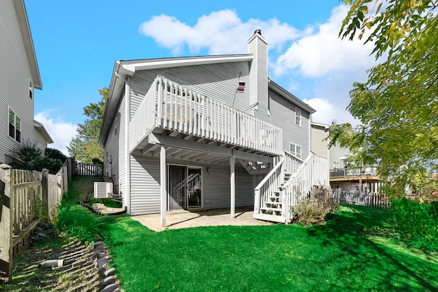 back of property with a patio, a deck, and a lawn