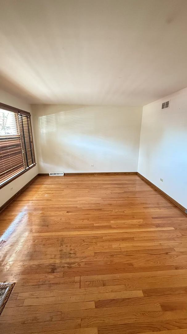 unfurnished room featuring light wood finished floors, baseboards, and visible vents