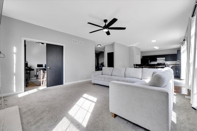 living room with ceiling fan and carpet