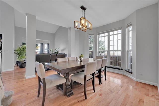 dining space with a wealth of natural light, a notable chandelier, and light wood-type flooring