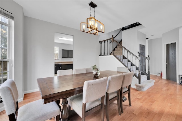 dining space with a notable chandelier and light hardwood / wood-style flooring