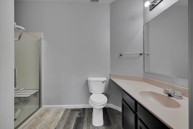 bathroom with vanity, hardwood / wood-style flooring, toilet, and an enclosed shower