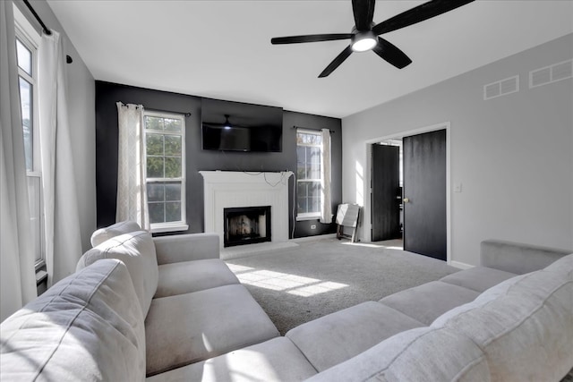 carpeted living room with ceiling fan