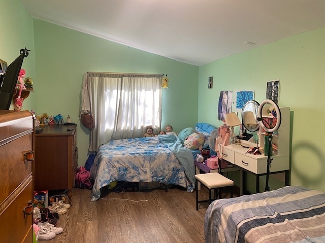 bedroom with wood-type flooring and vaulted ceiling