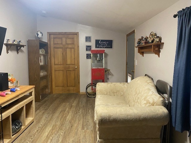 sitting room featuring vaulted ceiling and hardwood / wood-style flooring