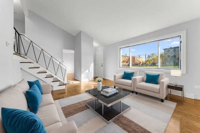 living room with light hardwood / wood-style flooring and high vaulted ceiling