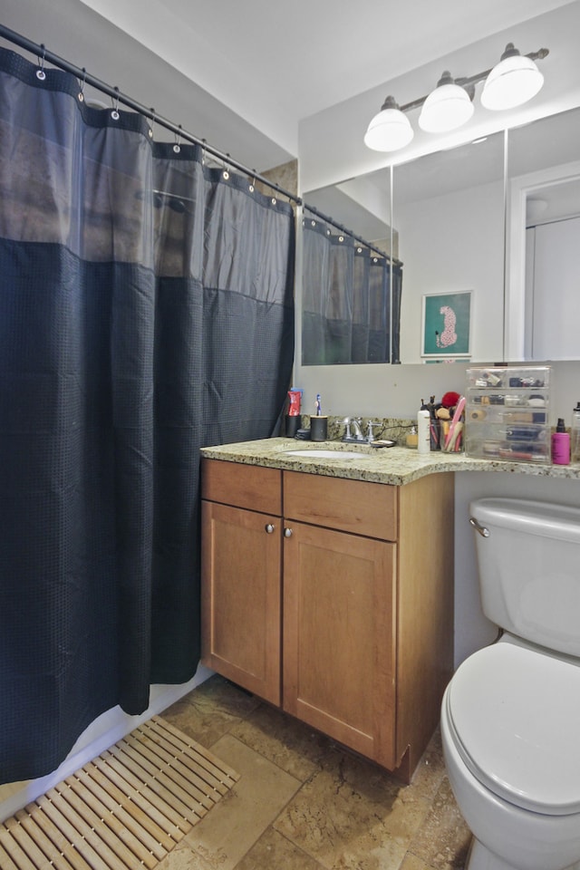 bathroom with vanity, a shower with shower curtain, and toilet