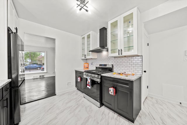 kitchen featuring white cabinets, light stone counters, backsplash, wall chimney exhaust hood, and stainless steel appliances