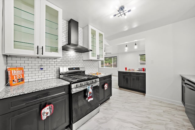 kitchen with light stone counters, stainless steel appliances, wall chimney exhaust hood, and white cabinets