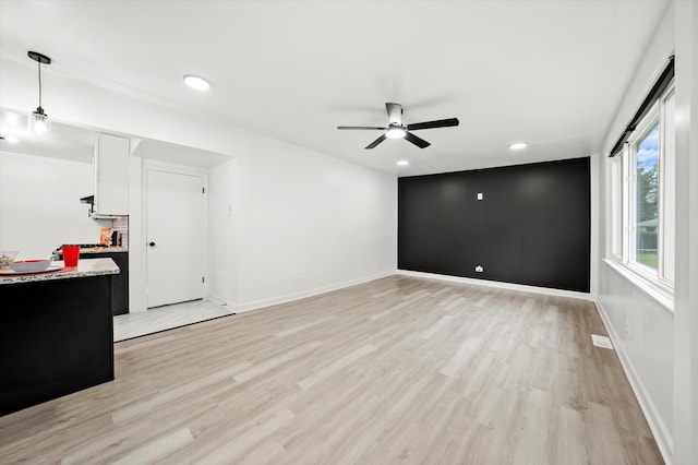 unfurnished living room featuring light hardwood / wood-style floors and ceiling fan