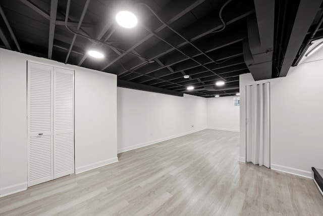 basement with light hardwood / wood-style flooring