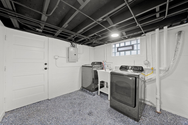 clothes washing area with dark carpet, electric panel, and washing machine and clothes dryer