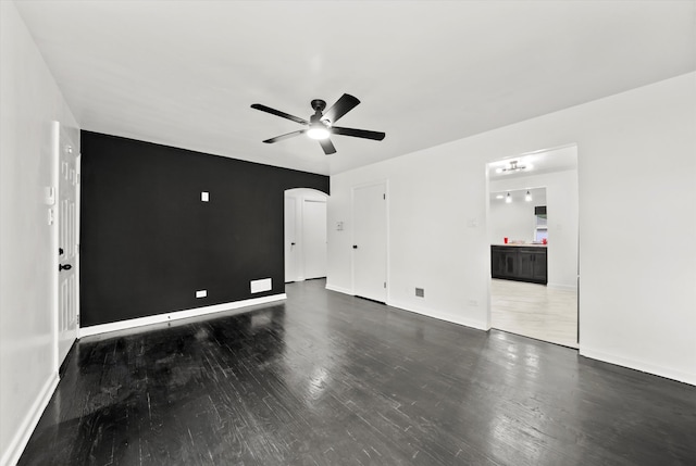 unfurnished room with dark wood-type flooring and ceiling fan