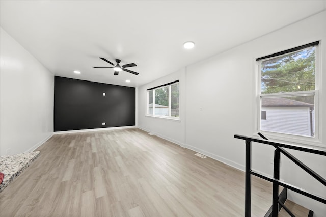 spare room with a wealth of natural light, light wood-type flooring, and ceiling fan