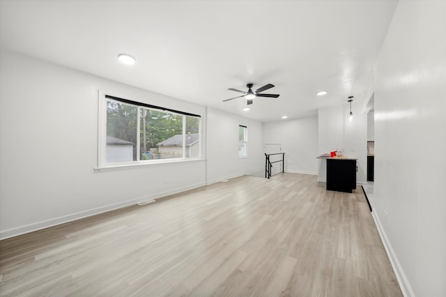 unfurnished living room with light hardwood / wood-style flooring and ceiling fan