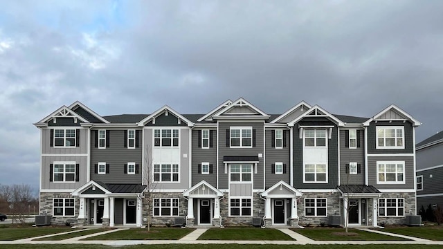 view of property featuring central AC and a front lawn