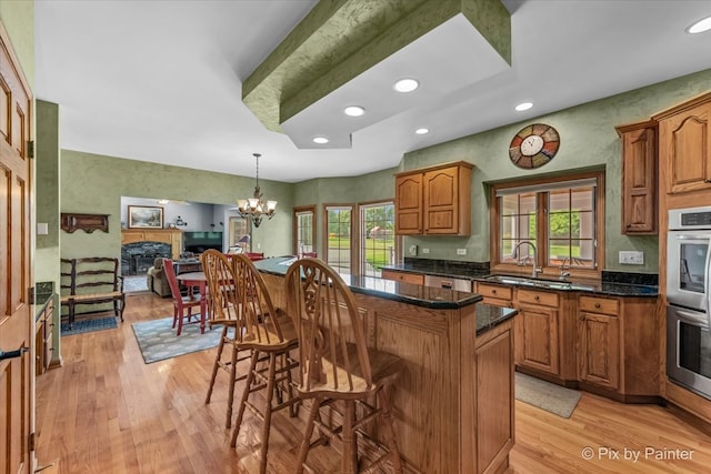 kitchen with sink, a healthy amount of sunlight, and light hardwood / wood-style flooring