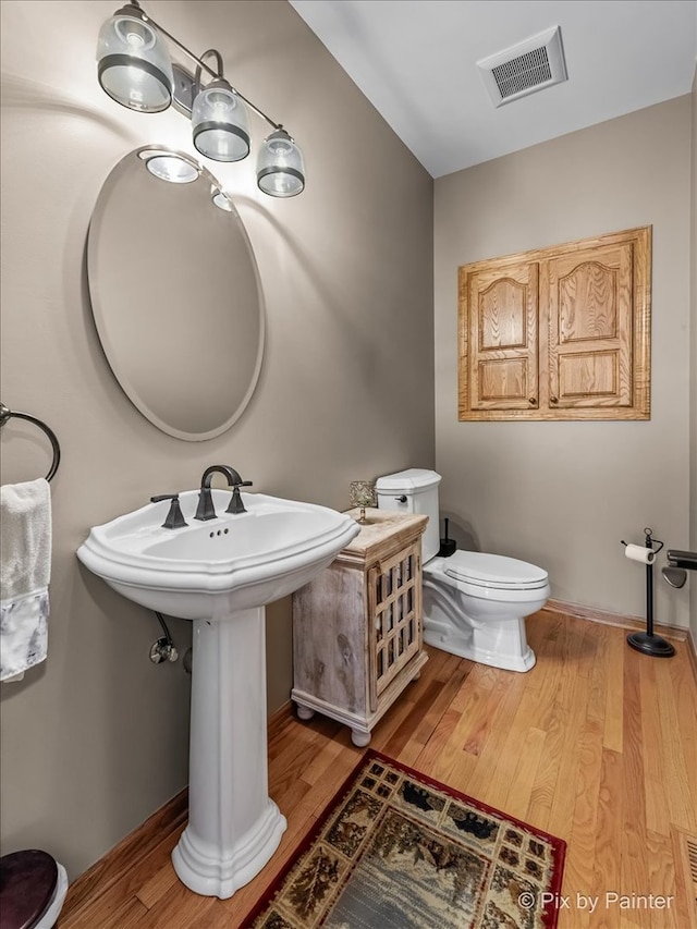 bathroom featuring wood-type flooring and toilet