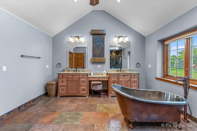 bathroom with vanity, a tub to relax in, and vaulted ceiling