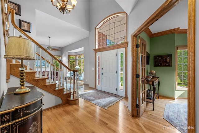 entrance foyer with a chandelier, a high ceiling, and light wood-type flooring