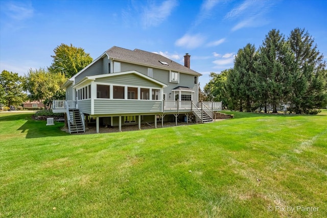 rear view of property featuring a yard, a deck, and a sunroom