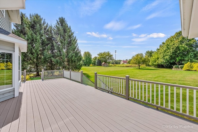 wooden deck featuring a lawn