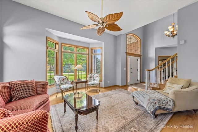 living room with hardwood / wood-style flooring and ceiling fan with notable chandelier