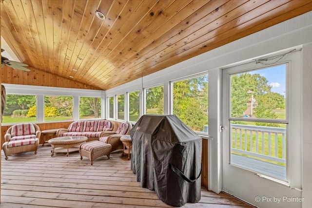 sunroom / solarium with lofted ceiling, wood ceiling, plenty of natural light, and ceiling fan