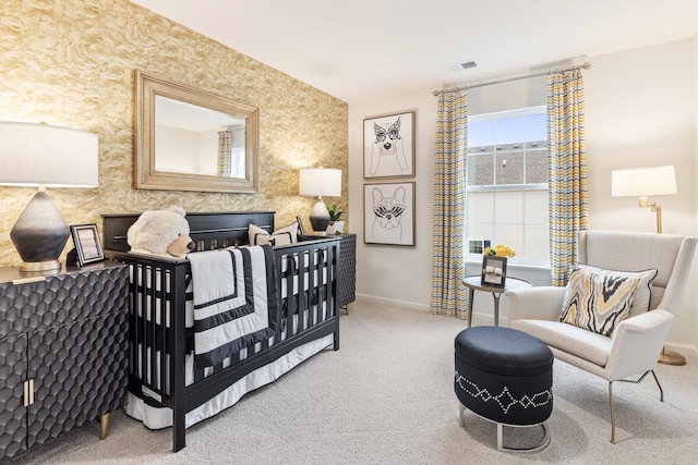 carpeted bedroom featuring a nursery area