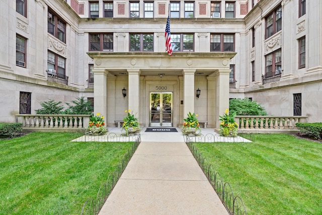 entrance to property featuring french doors and a lawn