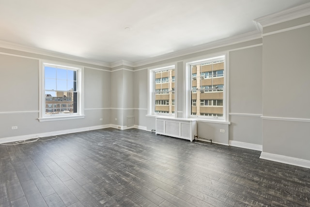 empty room featuring dark hardwood / wood-style flooring, crown molding, radiator heating unit, and plenty of natural light