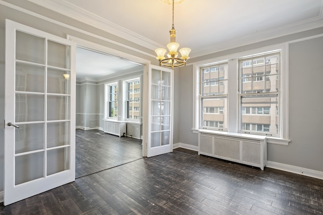 unfurnished dining area with dark wood-type flooring, a notable chandelier, radiator heating unit, and a wealth of natural light