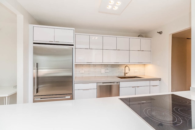 kitchen with white cabinetry, tasteful backsplash, appliances with stainless steel finishes, and sink