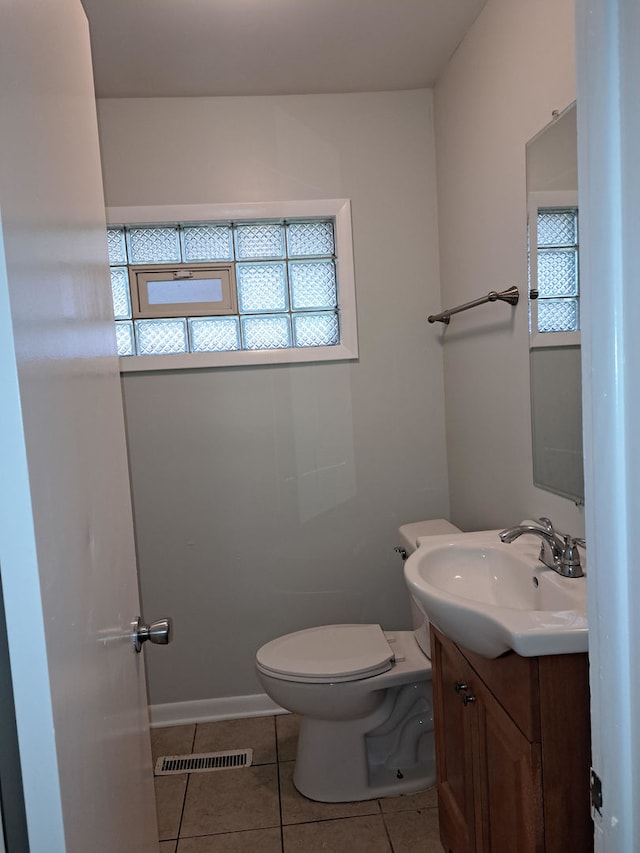 bathroom with toilet, vanity, tile patterned floors, and plenty of natural light