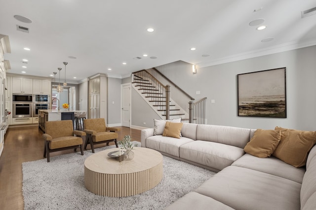 living room with hardwood / wood-style flooring, ornamental molding, and sink