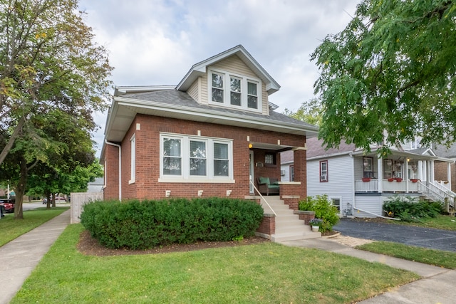 view of front of property with a porch and a front lawn