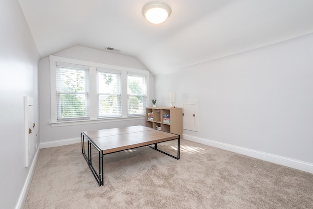 carpeted home office with vaulted ceiling