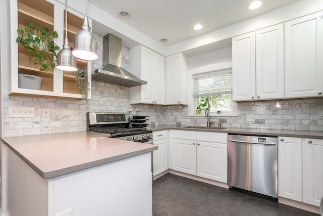 kitchen with white cabinetry, wall chimney exhaust hood, appliances with stainless steel finishes, and decorative light fixtures