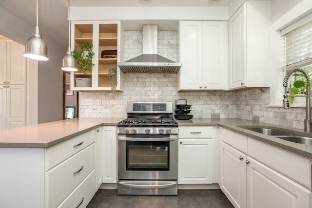 kitchen with sink, kitchen peninsula, white cabinetry, wall chimney exhaust hood, and stainless steel range with gas cooktop