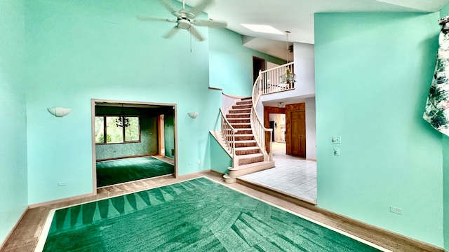 entryway featuring light hardwood / wood-style flooring, high vaulted ceiling, and ceiling fan with notable chandelier