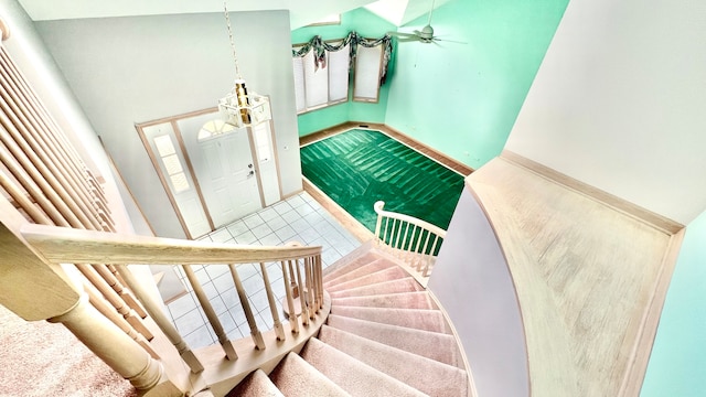 stairs with a towering ceiling and ceiling fan