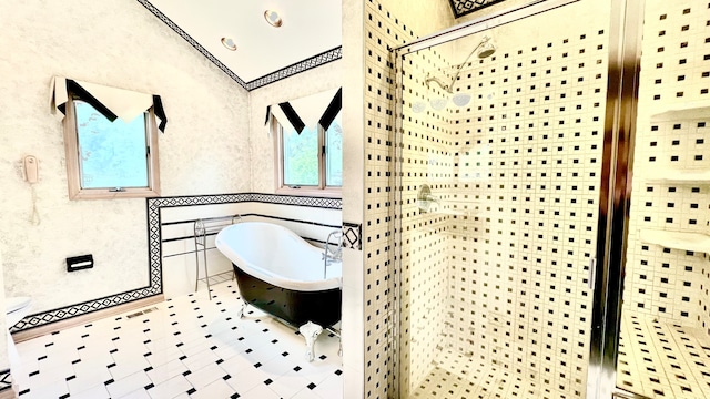 bathroom featuring shower with separate bathtub and tile walls