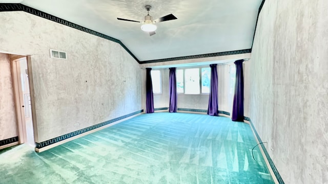 carpeted spare room featuring ceiling fan and vaulted ceiling