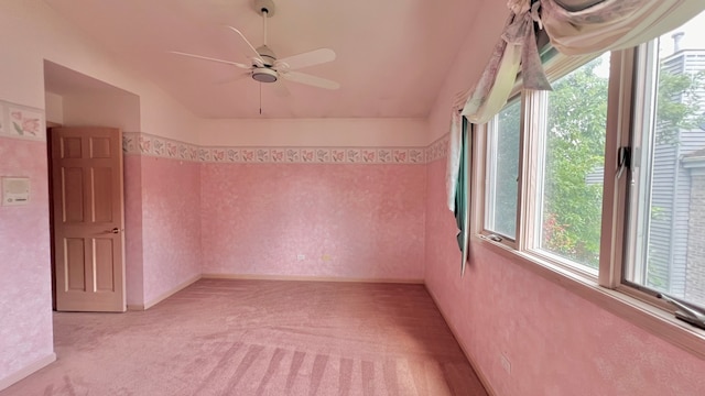 empty room featuring lofted ceiling, light carpet, and ceiling fan