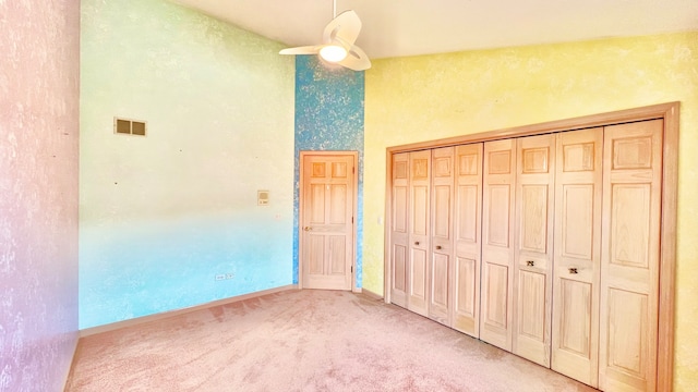 unfurnished bedroom featuring light colored carpet, a closet, and ceiling fan